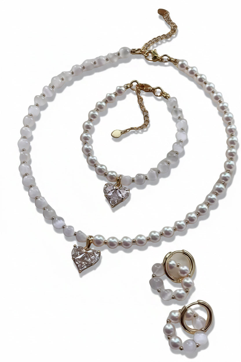 A pearl jewelry set featuring a choker necklace, bracelet, and matching earrings with gold-tone hardware and heart-shaped crystal charms, displayed on a clean white background.